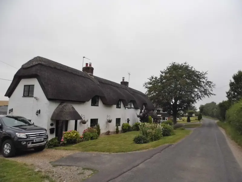 Photo: David Howard / CC BY-SA 2.0, via Wikimedia Commons Cottages by College Down Farm